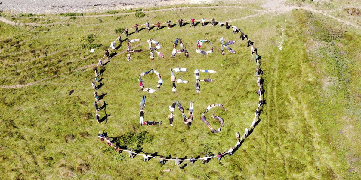 Climate actvists tresspass on the site of the proposed LNG terminal and lay on the ground forming the slogan “FRACK OFF LNG”