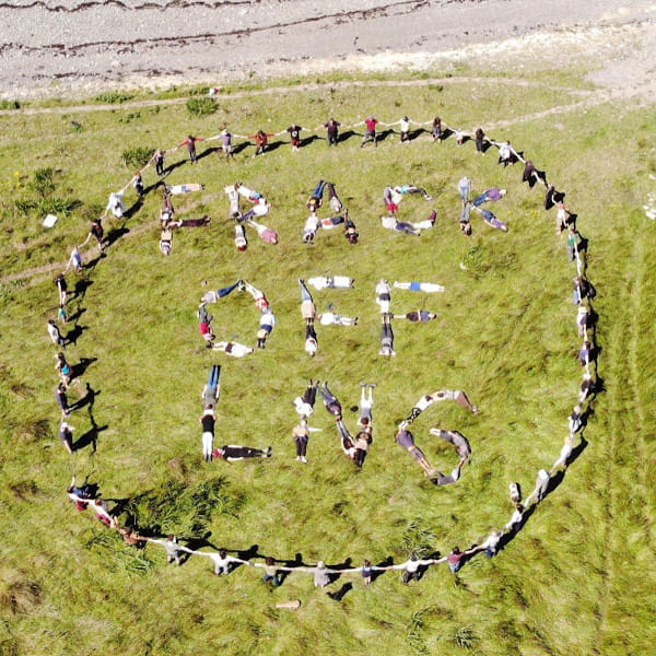 Climate actvists tresspass on the site of the proposed LNG terminal and lay on the ground forming the slogan “FRACK OFF LNG”