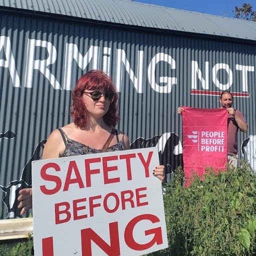 People Before Profit activists stand in front of a "Farming not Fracking" mural in Tarbert, near the site of the proposed LNG terminal.